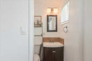 Half bathroom featuring vanity and toilet