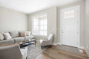 Living room with baseboards, recessed lighting, and light wood-style floors