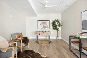 Living area with wood finished floors, ceiling fan, baseboards, and recessed lighting