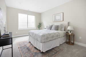 Bedroom with carpet flooring, visible vents, and baseboards