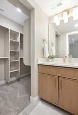 Bathroom with vanity, baseboards, and visible vents
