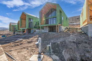 Rear view of house featuring a mountain view, an outdoor structure, and exterior structure