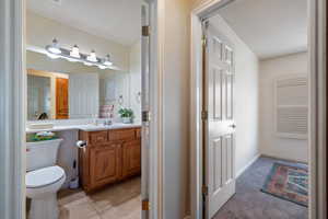 Bathroom featuring toilet, vanity, and tile patterned flooring