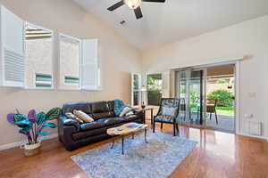 Living area featuring wood finished floors, ceiling fan, visible vents, and high vaulted ceiling