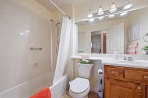 Full bathroom with vanity, tile patterned flooring, visible vents, toilet, and shower / bath combo