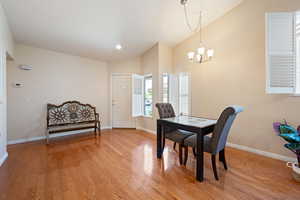 Dining area with baseboards, light wood finished floors, and a notable chandelier