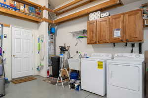 Laundry room with independent washer and dryer, cabinet space, and water heater
