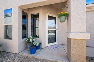 Doorway to property featuring stucco siding