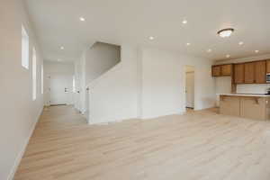 Unfurnished living room featuring recessed lighting, light wood-type flooring, and baseboards