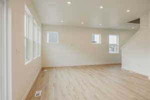 Unfurnished room with light wood finished floors, baseboards, visible vents, and recessed lighting