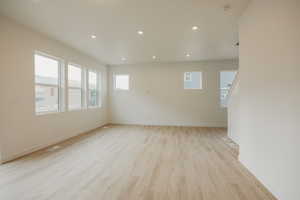 Spare room featuring light wood-type flooring, baseboards, recessed lighting, and visible vents