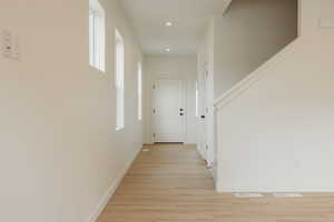 Hallway with recessed lighting, visible vents, light wood finished floors, and baseboards