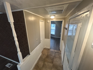Hall with brick wall and crown molding