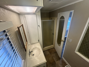 Full bath featuring baseboards, a shower stall, and vanity