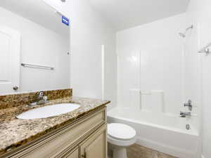 Full bath featuring toilet, vanity, tile patterned flooring, and shower / bathtub combination