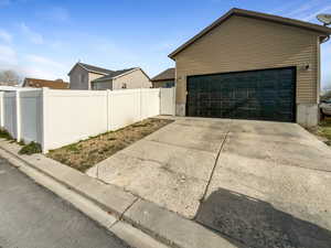 View of property exterior with an outbuilding, fence, and a garage