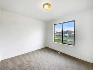 Unfurnished room with carpet flooring, baseboards, and visible vents