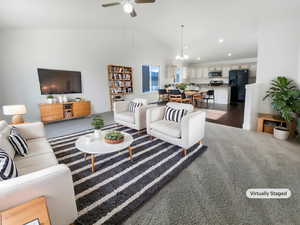 Living area with dark wood-style flooring, a ceiling fan, lofted ceiling, and recessed lighting