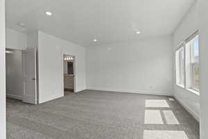 Unfurnished room featuring dark carpet, baseboards, and recessed lighting