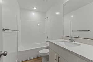 Bathroom with tub / shower combination, vanity, visible vents, toilet, and wood finished floors