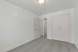 Unfurnished bedroom with a closet, carpet flooring, and baseboards