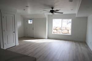 Entryway featuring wood finished floors, ceiling fan, and baseboards