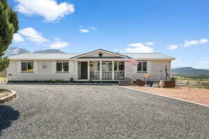 View of front of property with metal roof, a mountain view, and covered porch