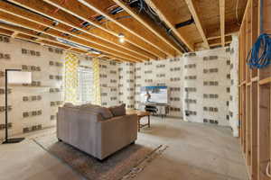 Living room featuring unfinished concrete flooring