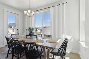 Dining space featuring light wood finished floors, an inviting chandelier, and baseboards