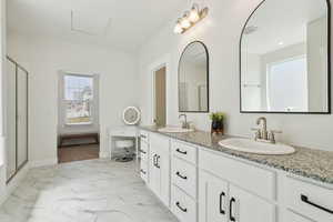 Full bath with double vanity, marble finish floor, a sink, and a stall shower