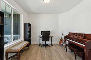 Office space featuring light wood-style flooring, baseboards, and a healthy amount of sunlight