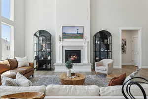 Living area with a high ceiling, wood finished floors, a fireplace, and baseboards
