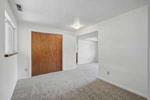 Unfurnished bedroom featuring carpet, visible vents, and baseboards