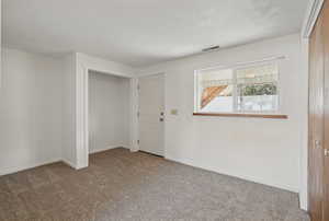 Spare room featuring visible vents, baseboards, and carpet flooring