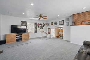 Carpeted living area with a ceiling fan, visible vents, and recessed lighting