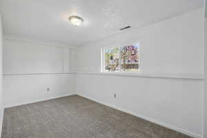 Carpeted spare room with baseboards and visible vents