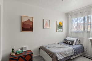 Bedroom with carpet flooring and a textured ceiling