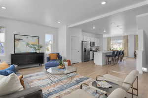 Living room with light wood-style flooring and recessed lighting