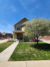 View of front of property with a porch and well kept lawn