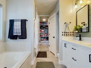 Primary Bathroom featuring a sink, double vanity, tile patterned flooring, a walk in closet, and a garden tub, Tile Surround Shower, Dual Shower heads