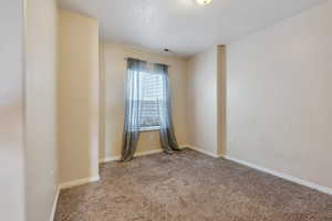 Carpeted spare room featuring visible vents and baseboards