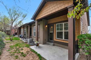 View of exterior entry featuring central air condition unit, a patio, and stucco siding