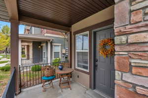 Property entrance featuring covered porch and stucco siding
