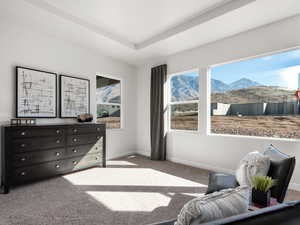 Living area with baseboards, a mountain view, and carpet floors