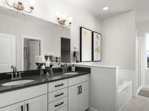 Full bath featuring a shower stall, double vanity, a garden tub, and a sink
