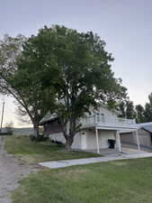 View of front facade featuring a front yard, a deck, and a garage