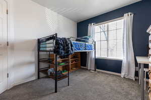 Bedroom featuring carpet flooring and baseboards
