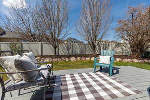 Wooden terrace with a fenced backyard and a patio