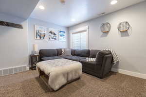 Living area with recessed lighting, visible vents, baseboards, and carpet floors