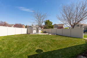 View of yard featuring a residential view, a fenced backyard, and an outdoor structure